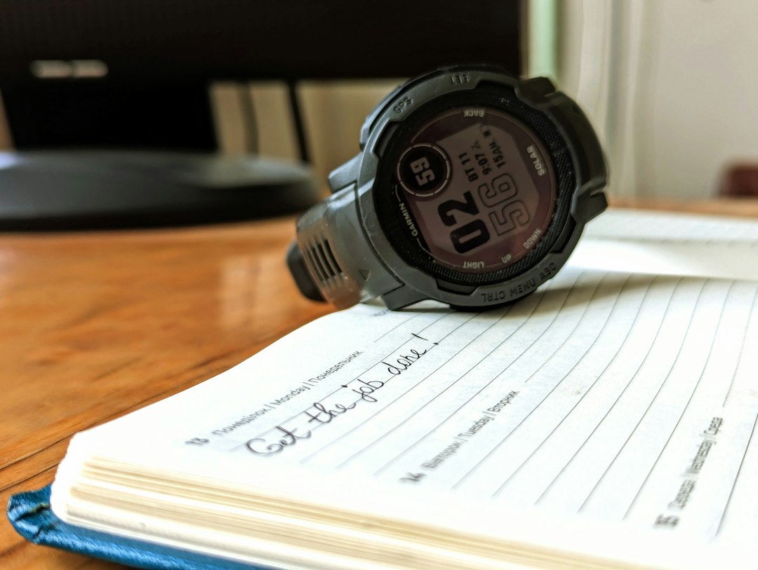 Wearable resting on a notebook beside charts, illustrating how routine ring data looks anonymous but retains identifying patterns