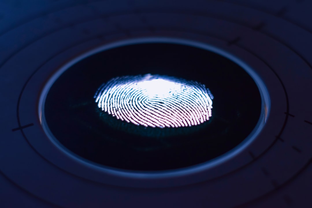 Glowing fingerprint on a circular scanner, visual metaphor for how gait and heart patterns identify people in de-identified datasets