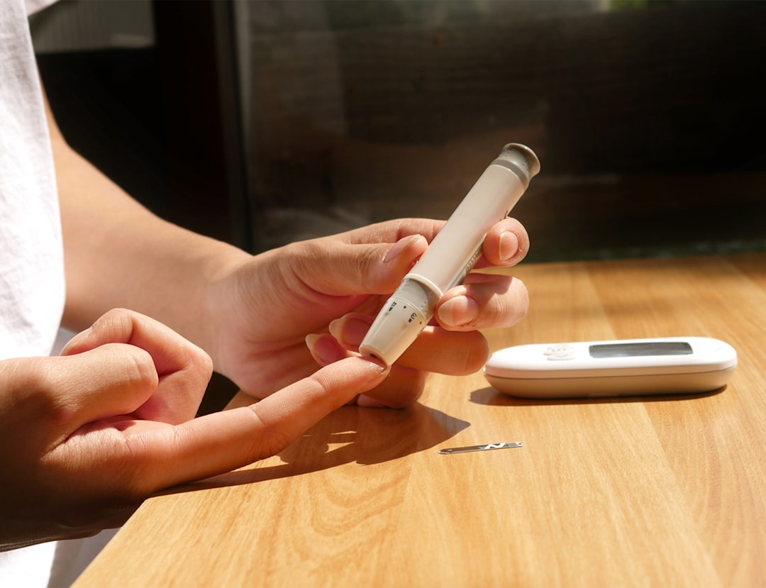 A continuous glucose monitor sensor being applied to a person's arm, showing the type of medical-grade device that now integrates with smart rings