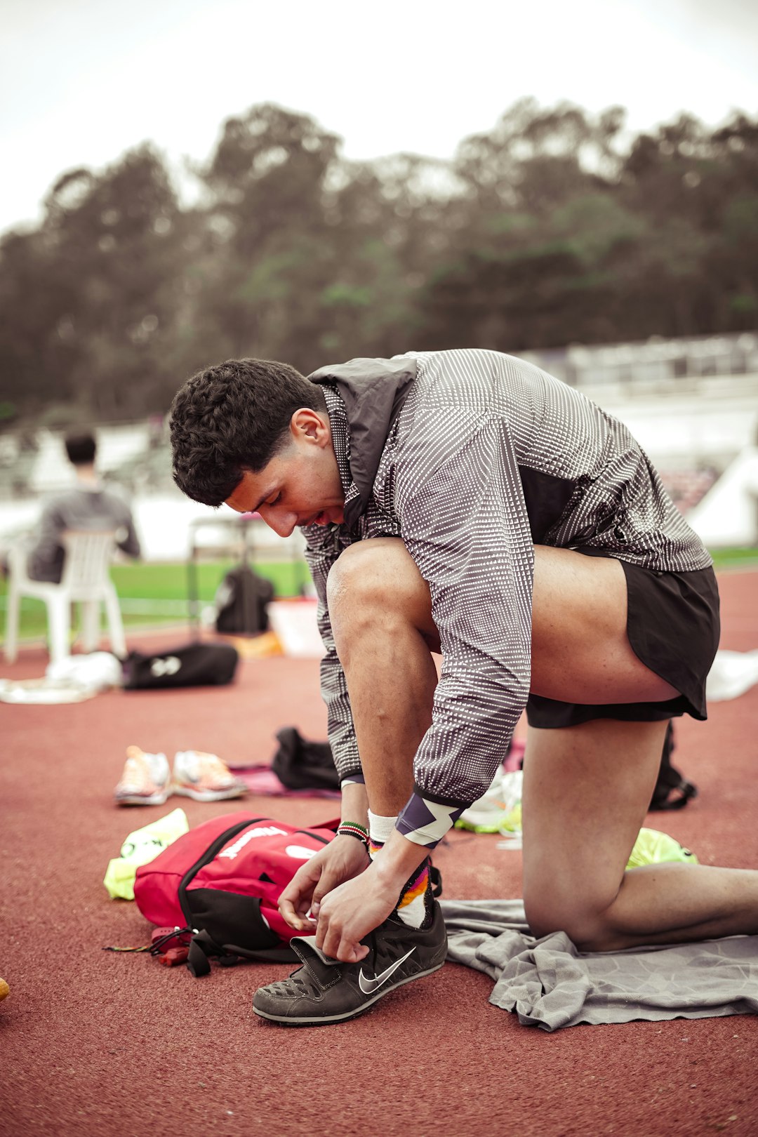 Man tying shoes before a race on track, illustrating planned training despite low recovery score