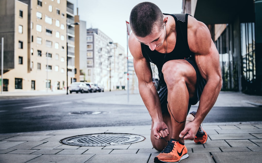 Runner tying shoes on concrete before morning workout, showing commitment to training plan
