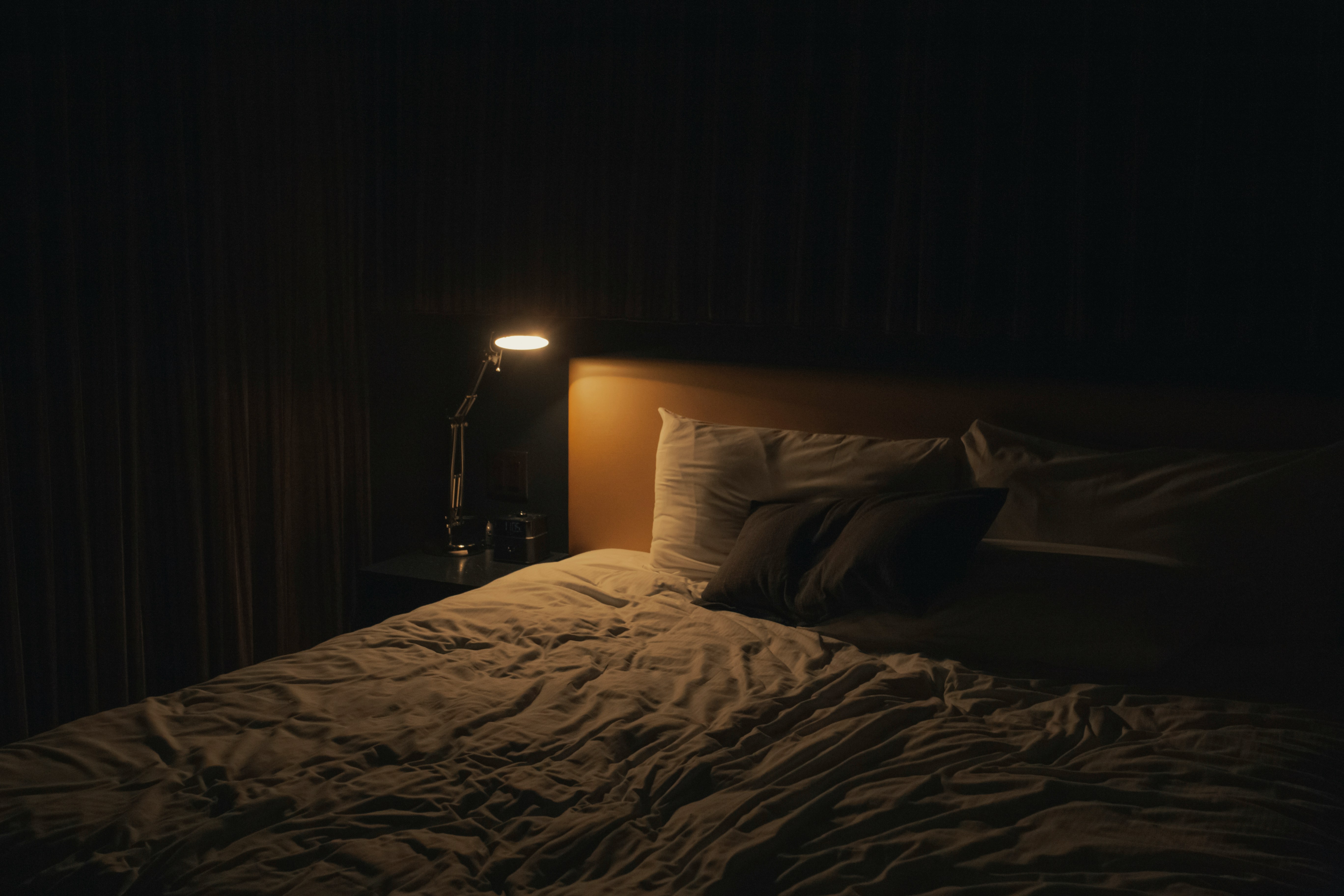 A dark bedroom with soft lighting, representing how antihistamines can create the illusion of restful sleep without the underlying brain state