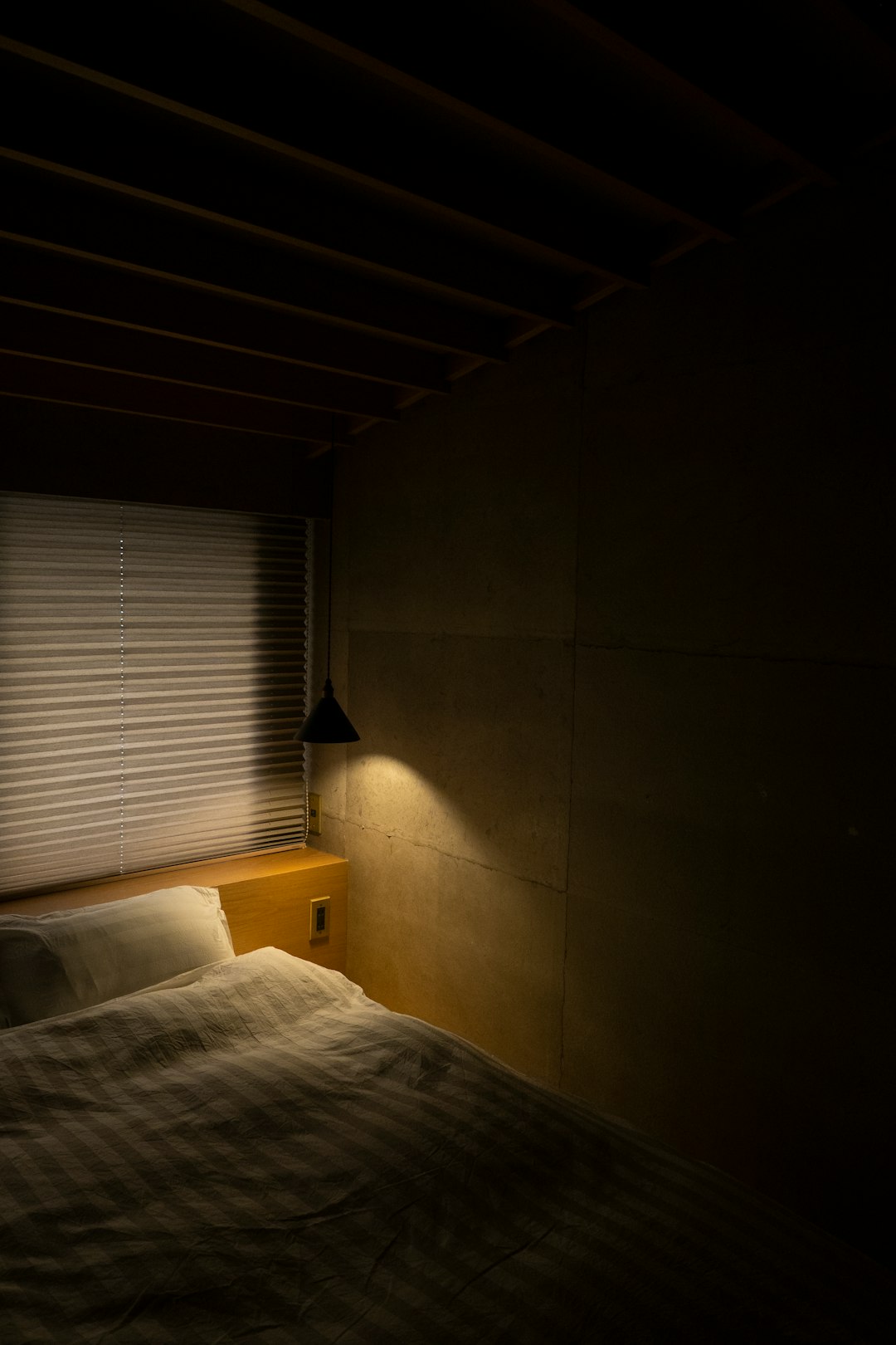 Table lamp glowing beside a bed at night showing the home environment for sleep tracking validation