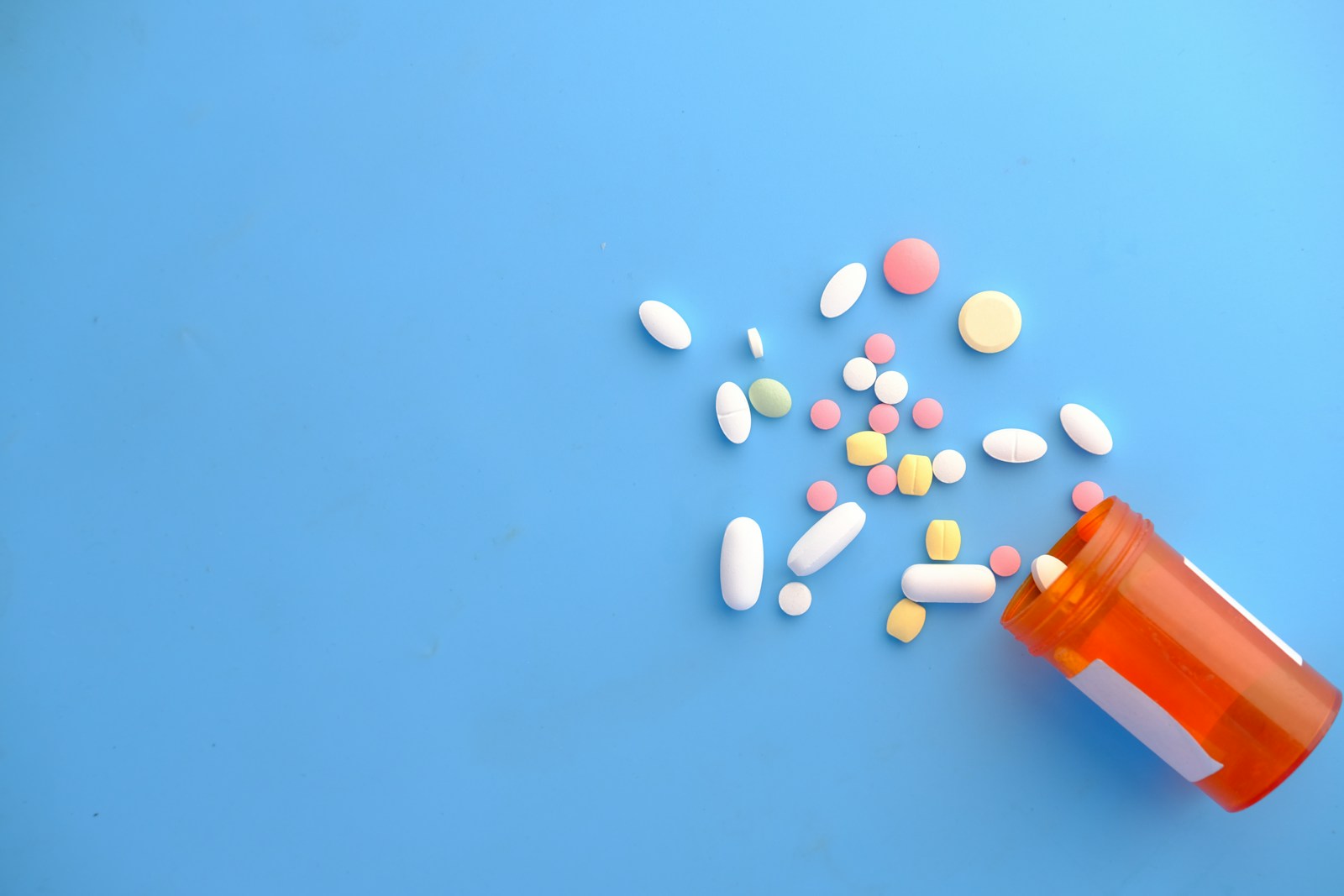 Prescription medication pills on a dark surface, representing GLP-1 drugs like Ozempic and Wegovy