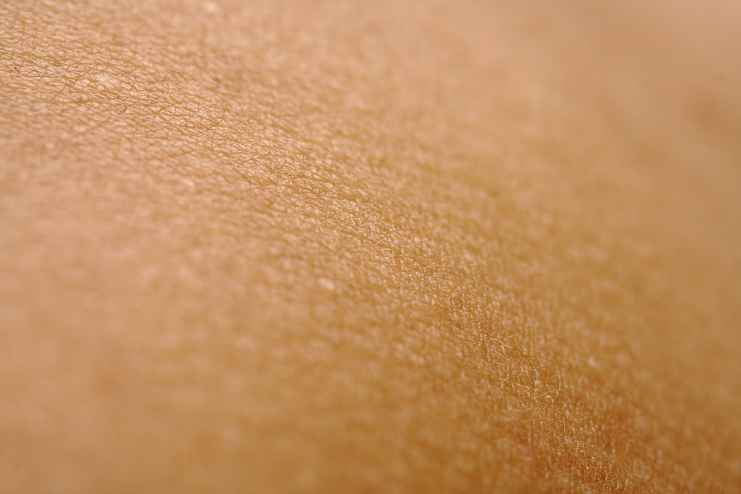 Extreme close-up of human skin texture showing pores and fine lines, illustrating the tiny blood volume changes a PPG sensor must detect