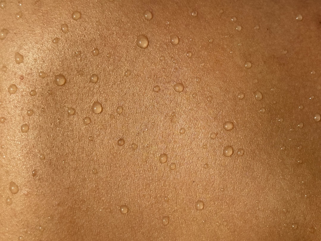 Close up of sweat droplets on human skin, showing the optical challenge that moisture creates for PPG sensors embedded in smart rings