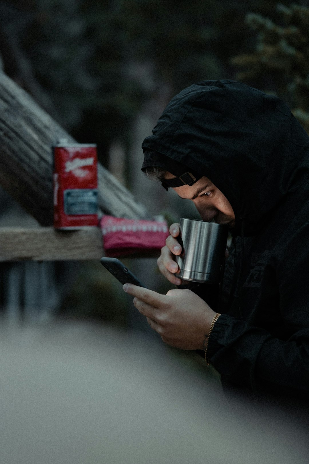 Person holding coffee and checking phone in soft morning light, showing a calmer way to read a low recovery day