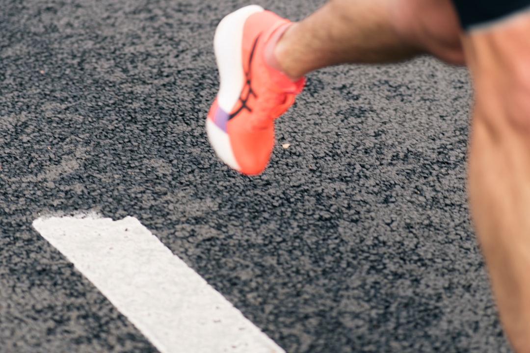 Runner's foot crossing a white track line mid-stride, representing repetitive cadence motion that confuses heart rate sampling