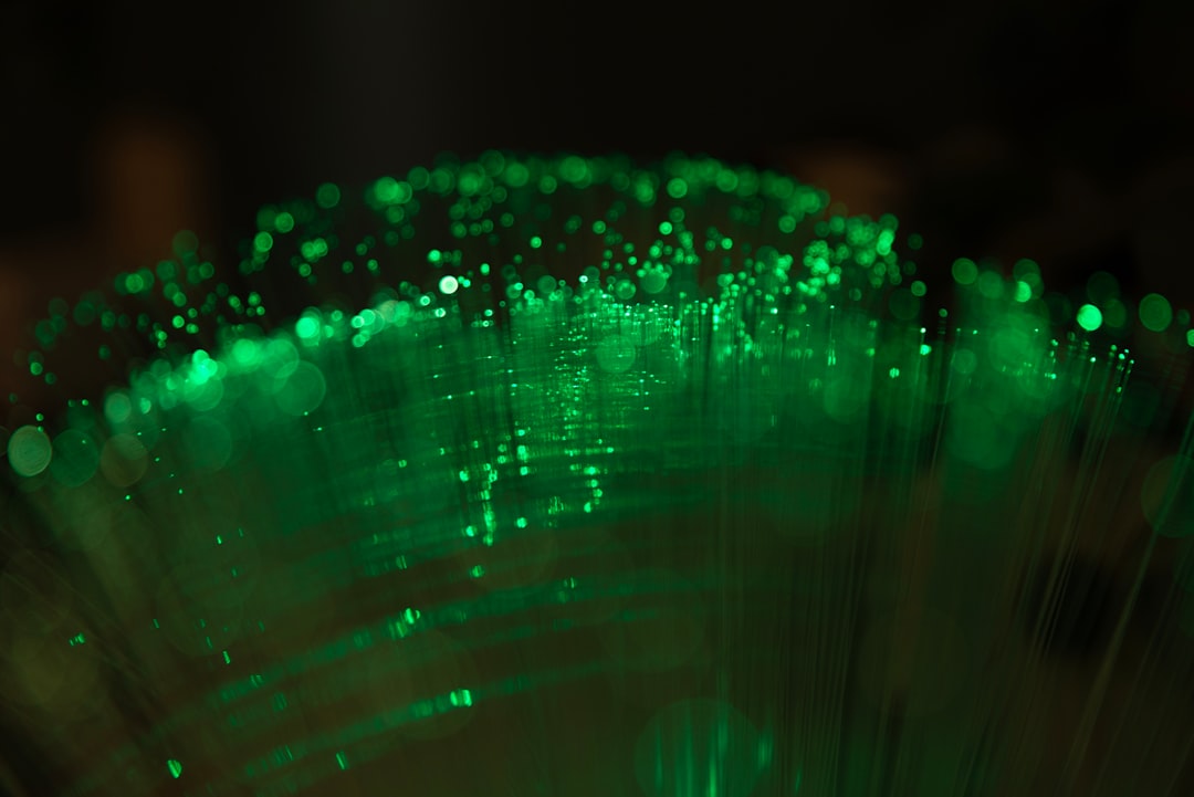 Macro of green LED light glowing in darkness, illustrating the green PPG wavelength smart rings use to detect blood volume pulses
