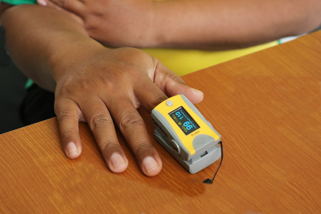 A medical pulse oximeter clipped to a finger. Consumer smart rings use the same PPG technology but lack the perfusion index warnings that medical devices are required to display