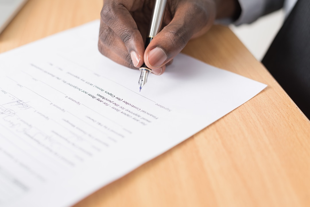 A person signing a contract with a pen, representing the terms of service most wearable users never read