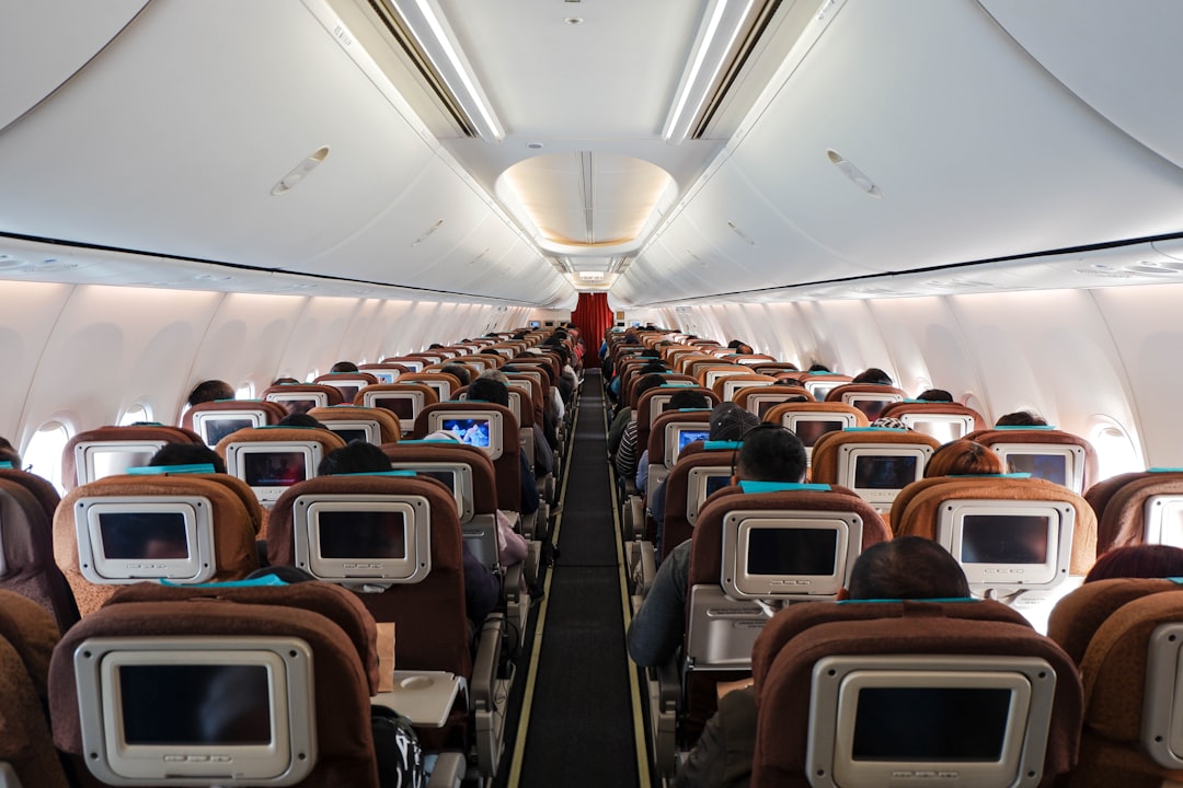 An airplane passenger cabin interior with rows of seats, the environment where immobility and dry air combine to suppress HRV by 15 to 30 percent