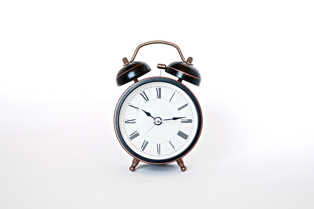 A white alarm clock on a bedside table in the dark, showing the early morning anxiety that sleep tracker data can create
